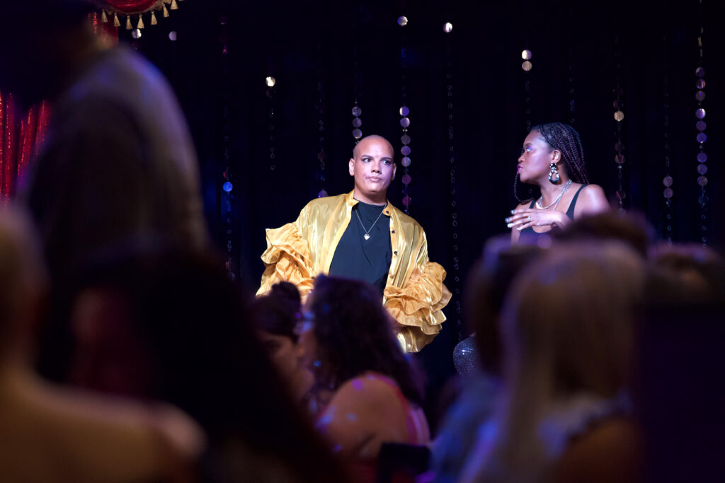 Mark Travis Rivera and a hostess on stage speaking in front of a crowd for Creative Mornings, a lecture series featuring creatives.